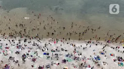 Libur perayaan Hari Raya Idul Fitri 1446 Hijriah atau Lebaran 2025 dimanfaatkan warga untuk berwisata ke sejumlah tempat, salah satunya Pantai Ancol Taman Impian, Jakarta. (Liputan6.com/Herman Zakharia)