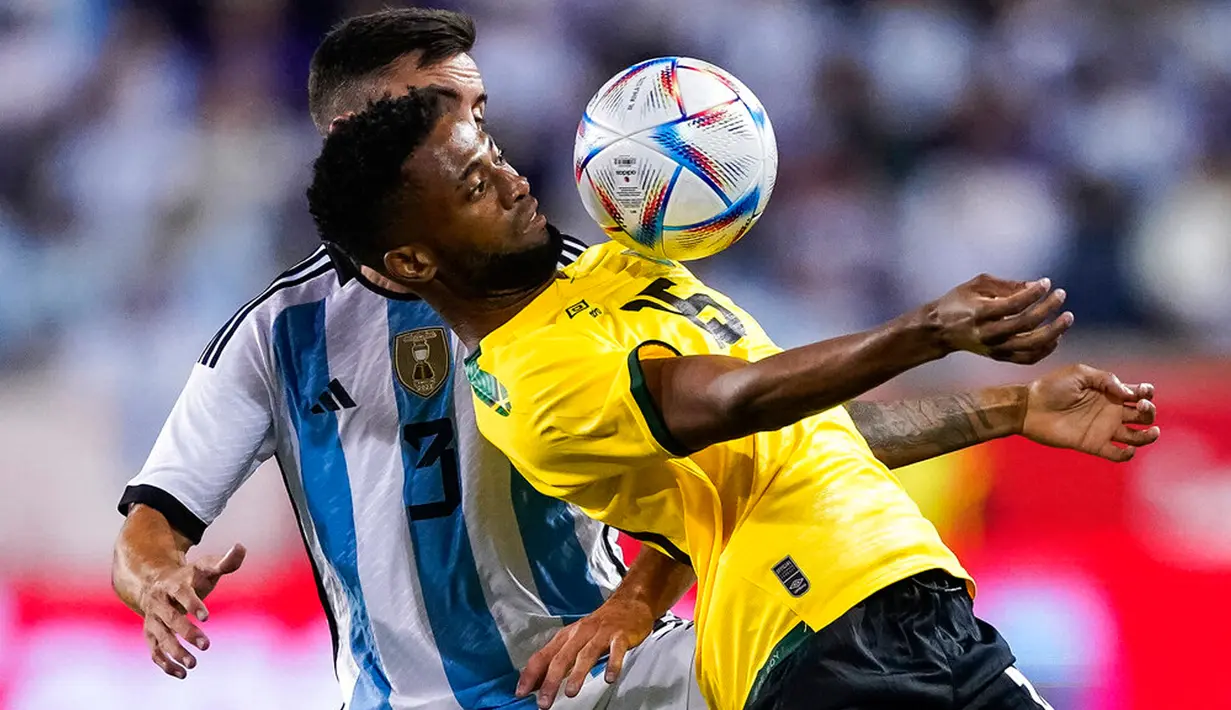 Pemain Jamaika Kaheem Parris (depan) berebut bola dengan pemain Argentina Nicolas Tagliafico pada pertandingan persahabatan di Harrison, New Jersey, Amerika Serikat, 27 September 2022. Argentina menang 3-0 dengan Messi mencetak dua gol. (AP Photo/Eduardo Munoz Alvarez)