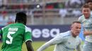 Striker Everton, Wayne Rooney (kanan) mencoba lolos dari kawalan pemain Gor Mahia pada pertandingan persahabatan di Tanzania, Kamis (13/7).  Rooney kembali tampil dalam seragam Everton setelah resmi meninggalkan Manchester United. (AP Photo/Khalfan Said)