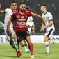 Striker Bali United, Ilija Spasojevic, berebut bola dengan bek Madura United, Jaimerson Xavier, pada laga Liga 1 2019 di Stadion Kapten I Wayan Dipta, Bali, Minggu (22/12). Bali kalah 0-2 dari Madura. (Bola.com/Aditya Wany)