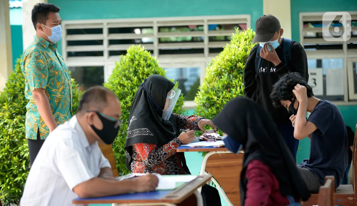 Guru membagikan kartu perdana Telkomsel dan Kuota 10 GB gratis kepada siswa kelas 7, 8 dan 9 SMPN 18, Pondok Benda, Pamulang, Tangsel, Kamis (10/9/2020). Program Kartu Perdana Merdeka itu untuk mendukung program pembelajaran jarak jauh (PJJ) di masa pandemi covid-19. (merdeka.com/Dwi Narwoko)