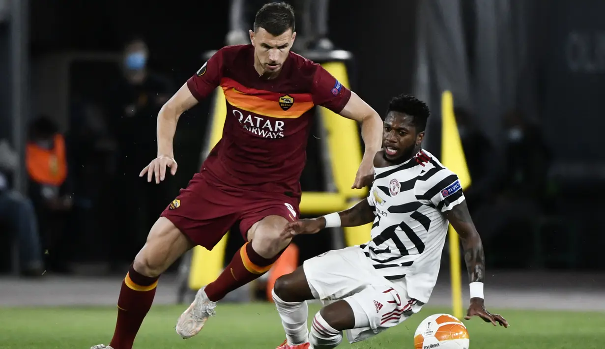Striker AS Roma, Edin Dzeko (kiri) berebut bola dengan gelandang Manchester United, Fred pada laga leg kedua semifinal Liga Europa 2020/2021 di Olimpico Stadium (6/5/2021). Edin Dzeko total mencetak 9 gol dan 2 assist dari 18 laga bersama Wolfsburg, Manchester City dan AS Roma saat menghadapi Manchester United di semua ajang. Gol terakhirnya terjadi pada laga leg kedua semifinal Liga Europa 2020/2021 saat AS Roma menang 3-2. (AFP/Filippo Monteforte)