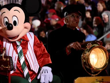Karakter Mickey Mouse menaiki mobil saat mengikuti Parade Natal Hollywood ke-85 di Los Angeles, California, AS (27/11). Parade ini dirayakan tiap tahunnya untuk menyambut datangnya Hari Raya Natal. (Reuters/Phil McCarten)