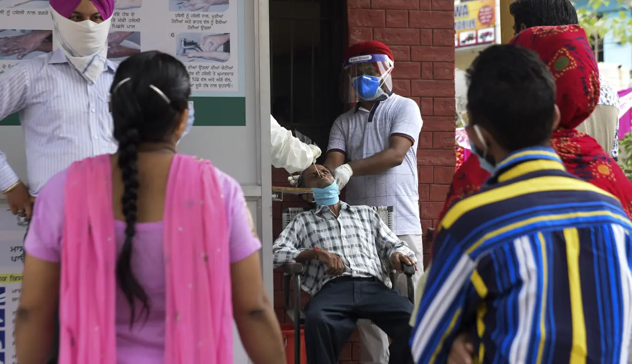 Petugas kesehatan mengambil sampel swab seorang pria untuk menguji virus corona Covid-19 di sebuah rumah sakit di Amritsar (2/9/2020). (AFP/Narinder Nanu)