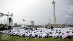 Massa aksi damai 2 Desember bersujud saat menunaikan ibadah salat Jumat di Monas, Jakarta, Jumat (2/12). Meski hujan mengguyur, massa tetap bertahan di saf masing-masing dan melangsungkan salat Jumat bersama-sama. (Liputan6.com/Faizal Fanani)
