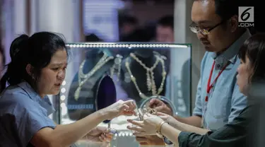 Pengunjung melihat perhiasan di salah satu stan pameran Jakarta Inernational Jewellery Fair 2019 di Jakarta, Kamis (4/4). Ajang Jakarta International Jewellery Fair 2019 diselenggarakan oleh Asosiasi Perhiasan Emas dan Permata Indonesia (APEPI) 4-7 April 2019 di JCC. (Liputan6.com/Faizal Fanani)