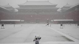 Patung Bing Dwen Dwen, maskot Olimpiade Musim Dingin 2022 terlihat di gerbang Kota Terlarang saat salju turun di Beijing, China (18/3/2022). Gelombang dingin melanda banyak bagian China, menyebabkan suhu turun dan mengganggu lalu lintas di daerah yang terkena dampak. (AP Photo/Ng Han Guan)