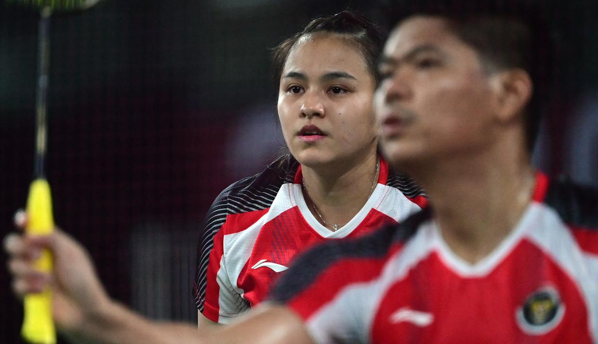 Ganda campuran Indonesia Melati Daeva Oktavianti melihat Praveen Jordan saat melawan Simon Leung dan Gronya Somerville (Australia) di Grup C cabang bulu tangkis Olimpiade Tokyo 2020 di Musashino Forest Sports Plaza, Sabtu (24/7/2021). Praveen / Melati menang 20-22, 21-17 dan 21-13. (Pedro PARDO/AFP)
