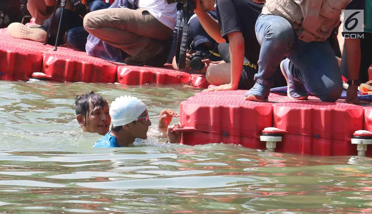 Wagub DKI Jakarta Sandiaga Uno mencapai garis finish saat bertanding melawan Menteri KKP, Susi Pudjiastuti melintasi danau sepanjang 1k selama Festival Danau Sunter di Jakarta, Minggu (25/2). (Liputan6.com/Angga Yuniar)