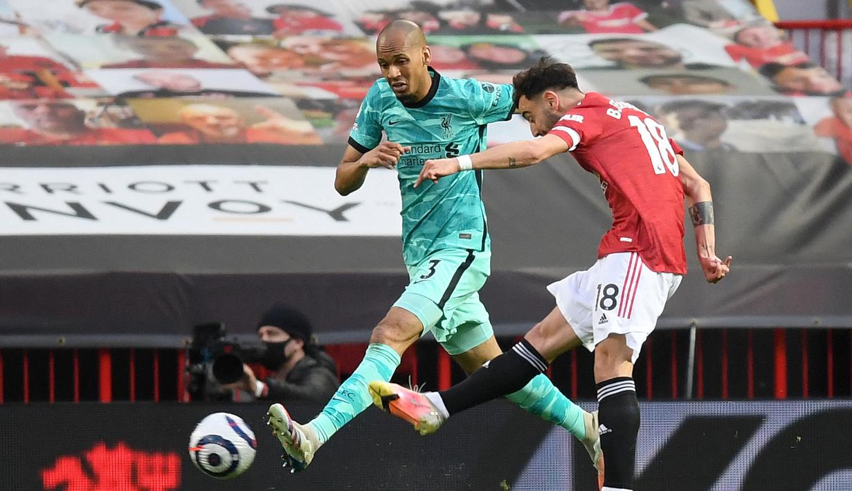 Gelandang Manchester United, Bruno Fernandes (kanan) melepaskan tendangan yang berbuah gol pertama timnya ke gawang Liverpool dalam laga lanjutan Liga Inggris 2020/2021 pekan ke-35 di Old Trafford, Kamis (13/5/2021). Manchester United kalah 2-4 dari Liverpool. (AFP/Michael Regan/Pool)
