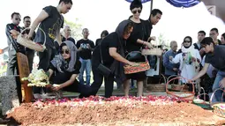 Eva Celia menaruh bunga di pemakaman neneknya, Nien Lesmana di TPU Tanah Kusir, Jakarta, Rabu (28/6). Ibu dari Indra Lesmana dan Mira Lesmana meninggal dunia pada usai 88 tahun. (Liputan6.com/Herman Zakharia)