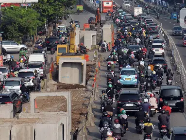Alat berat yang tengah mengerjakan proyek pembangunan saluran air (drainase) berada di tengah Jalan KH. Abdullah Syafei, Jakarta, Kamis (13/7/2023). Proyek pembangunan drainase membuat lalu lintas tersendat karena terjadi penyempitan jalan dan pengendara yang melintas harus mengurangi kecepatannya. (merdeka.com/Imam Buhori)