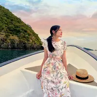 Berlatar langit yang sangat indah, Tiffany berpose di sebuah perahu dengan gaun cantik. Pesonanya semakin memukau dengan dress lengan pendek bermotif floral, disempurnakan dengan rambut panjangnya yang diikat low pony-tail. Foto: Instagram.