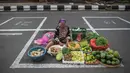 Pedagang menunggu pembeli di dalam garis petak-petak untuk menerapkan jaga jarak (physical distancing) di sepanjang jalan di Surabaya, Selasa (2/6/2020). Garis petak-petak bagi pedagang itu sebagai langkah pencegahan penyebaran COVID-19. (Photo by Juni Kriswanto / AFP)
