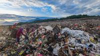 Warga yang berprofesi sebagai pemulung mengumpulkan sampah plastik dengan latar belakang Gunung Gede-Pangrango di Tempat Pembuangan Akhir Galuga, Bogor, Kamis (6/11/2025). Selain itu, capping juga mencegah sampah berhamburan akibat tertiup angin, serta mengontrol pelepasan gas metana dari tumpukan sampah. (merdeka.com/Arie Basuki)