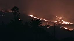 Gunung berapi Cumbre Vieja memuntahkan lava saat terus meletus di pulau Canary La Palma, Spanyol pada Sabtu (16/10/2021). Gunung berapi di salah satu Kepulauan Canary di barat laut Afrika sejauh ini telah menghancurkan lebih dari 1.800 bangunan, sebagian besar rumah. (AP Photo/Daniel Roca)