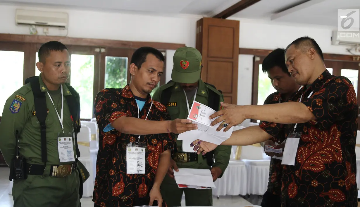 Dua petugas keamanan berjaga saat penghitungan suara Pilkada Jawa Barat 2018 di TPS 06 Nagrak, Gunung Putri, Bogor, Rabu (27/6). Di TPS ini pasangan Nomor Urut 4, Deddy Mizwar dan Dedi Mulyadi menang telak dengan 119 suara. (Liputan6.com/Herman Zakharia)
