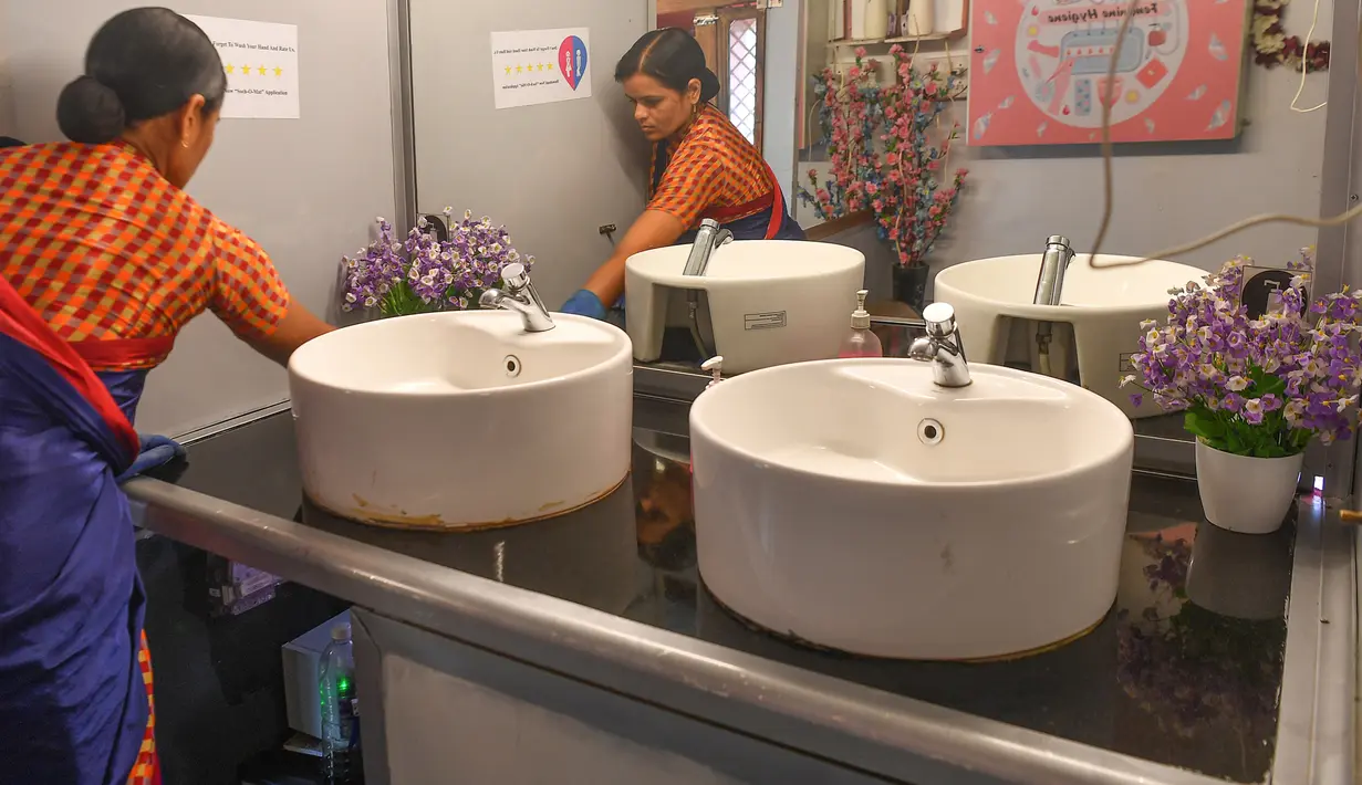 Foto pada 9 Februari 2020 menunjukkan petugas membersihkan bagian dalam toilet keliling di sebuah bus di taman umum di Pune, India. Proyek Ti Toilet, sebuah bus yang diubah menjadi toilet dan diluncurkan pada tahun 2016, adalah gagasan Ulka Sadalkar dan Rajeev Kheer. (Indranil MUKHERJEE/AFP)