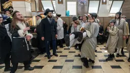 Pria Yahudi ultraortodoks menari selama Festival Purim di lingkungan ultraortodoks Mea Shearim, Yerusalem, 8 Maret 2023. Hari Raya Purim merupakan perayaan keselamatan orang Yahudi dari genosida di Persia kuno, seperti yang diceritakan dalam Gulungan Ester. (AP Photo/Ohad Zwigenberg)