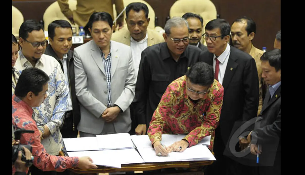 Mendagri Tjahjo Kumolo menandatangi Perppu Pilkada dalam rapat kerja bersama Komisi II DPR di Gedung Nusantara, Kompleks Parlemen Senayan, Jakarta, Senin (19/1/2015). (Liputan6.com/Andrian M Tunay)