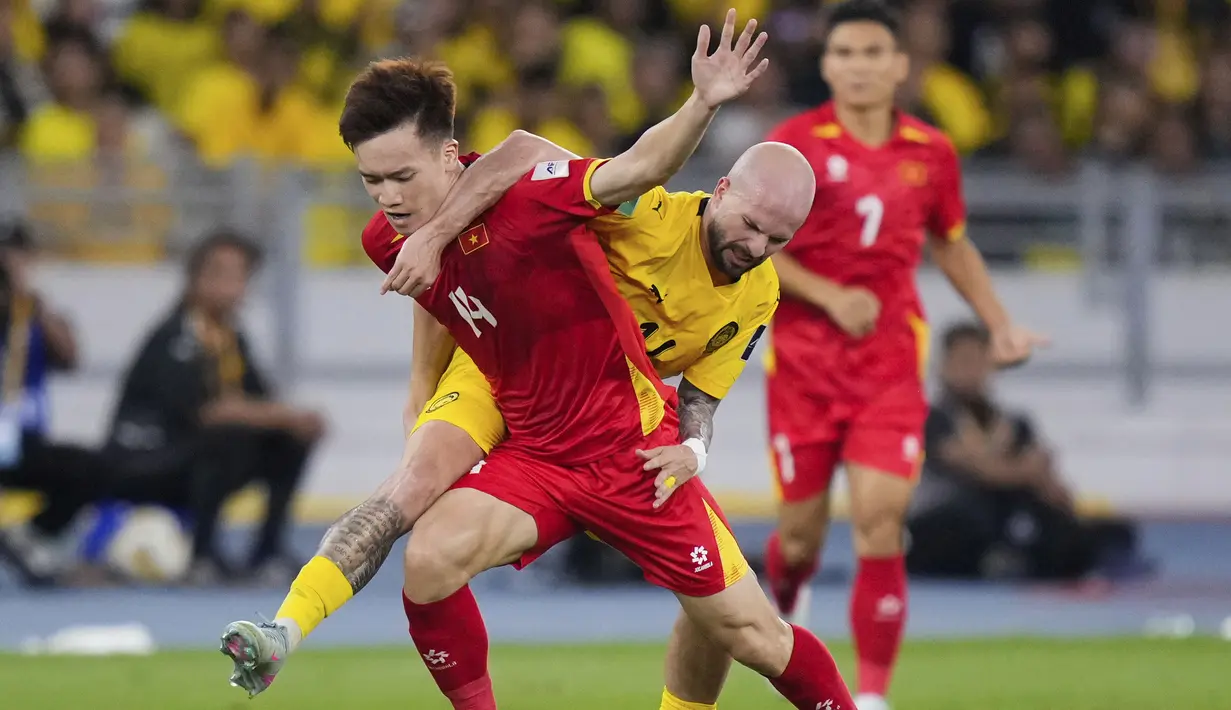 Pemain Malaysia, Joao Victor Figueiredo (kanan) berebut bola dengan pemain Vietnam, Nguyen Hoang Duc dalam laga Grup F Kualifikasi Piala Asia 2027 di Stadion Nasional Bukit Jalil, Kuala Lumpur, Malaysia, Selasa (10/06/2025). (AP Photo/Vincent Thian)