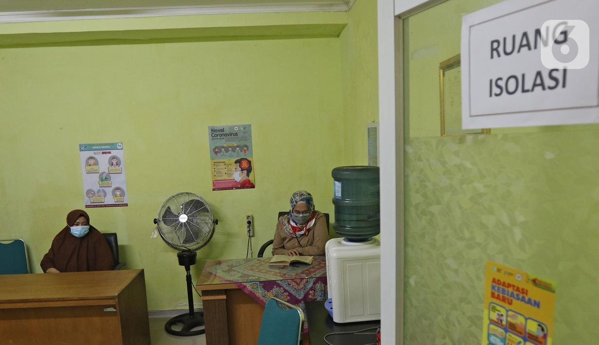 Guru sedang berjaga di ruang isolasi  SMKN 51, Jakarta, Rabu (7/4/2021). Para murid diwajibakan membawa makanan sendiri  dan mengikuti syarat & panduan sekolah tatap muka seperti membuka pintu dan jendela.(Liputan6.com/Herman Zakharia)