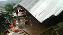 Warga mencari sisa-sisa barang yang bisa diselamatkan dari sebuah rumah yang ambruk akibat tanah longsor di Kecamatan Kintamani, Bali, Jumat (10/2). Sebanyak 12 orang dilaporkan meninggal akibat musibah ini. (STR/NATIONAL DISASTER AGENCY/AFP)