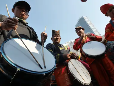 Masyarakat Maninjau Sumatera Barat memainkan Tambua Tansa di areal car free day (CFD), Jakarta, Minggu (8/7). Parade Tambua Tansa Minangkabau ini mengawali rangkaian Festival Danau Maninjau pada Oktober 2018 mendatang. (Liputan6.com/Herman Zakharia)