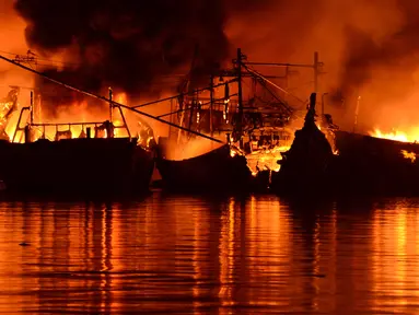 Sebanyak 18 kapal nelayan terbakar Pelabuhan Muara Baru, Penjaringan, Jakarta Utara, Sabtu (23/2). Informasi kebakaran diterima petugas sekitar pukul 15.19 WIB dan sempat terdengar suara ledakan dari kapal. (merdeka.com/Imam Bukhori)