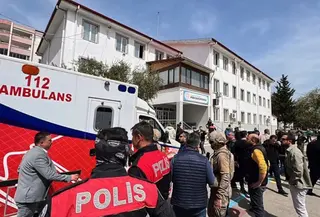 Petugas keamanan dan tim darurat Turki berdiri di halaman sekolah menengah lokasi penembakan di Kahramanmaras, Turki, Rabu (15/4/2026). (Dok. IHA/AP)