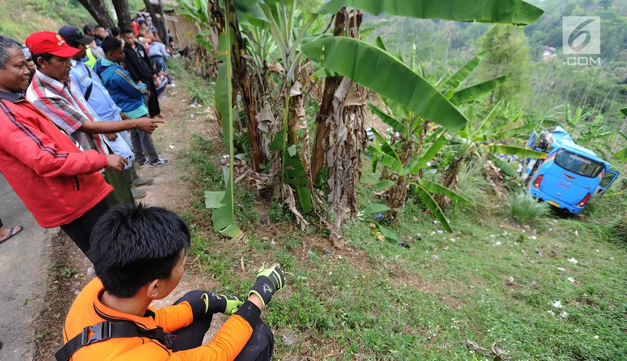 Warga melihat sebuah bus berpenumpang wisatawan yang masuk jurang di jalur alternatif Cikidang, Sukabumi, Minggu (9/9). Selain menimbulkan korban jiwa, kecelakaan bus masuk jurang itu juga menyebabkan 17 orang luka-luka. (Merdeka.com/Arie Basuki)