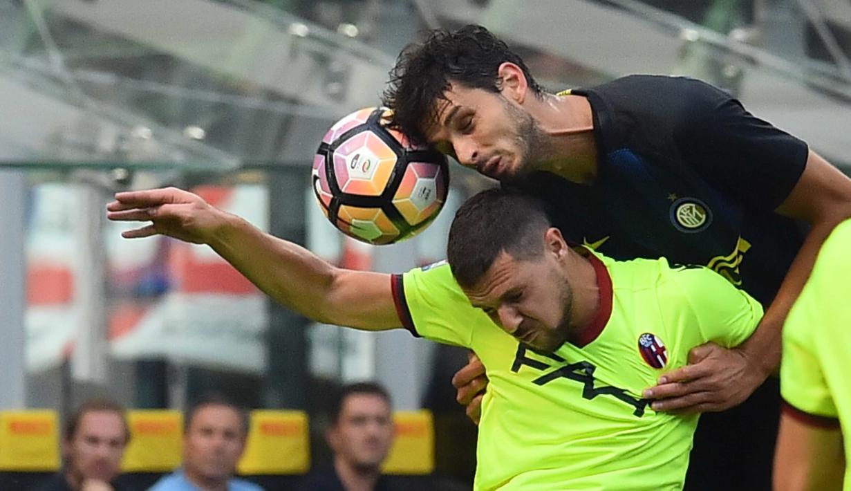 Pemain Bologna, Mattia Destro (kanan) berduel dengan pemain Inter Milan, Andrea Ranocchia pada lanjutan Serie A Italia di Stadion Giuseppe Meazza, Milan, (25/9/2016). (AFP/ Giuseppe Cacace)
