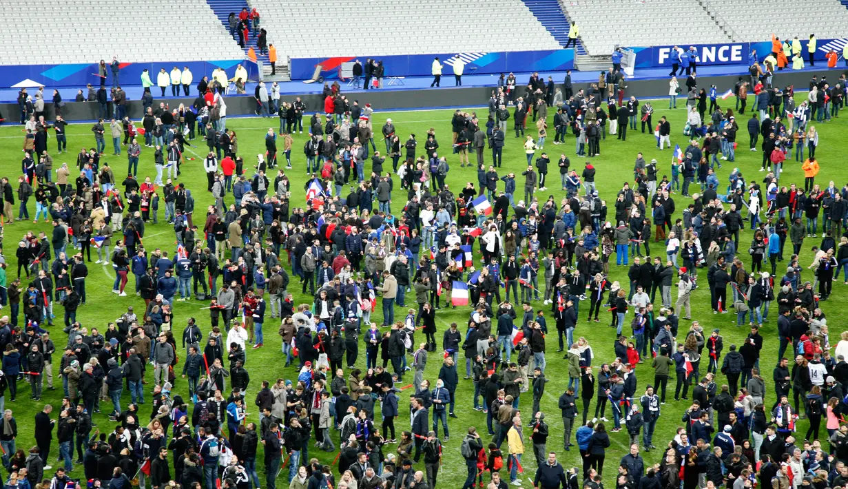 Penonton menunggu di lapangan stadion Stade de France di Seine-Saint-Denis, Paris (13/11). Serangan terjadi saat Timnas Prancis sedang menjamu Jerman dalam pertandingan persahabatan. AFP (PHOTO/Matthieu ALEXANDRE)