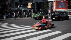 Seorang wanita mengendarai go-kart di persimpangan Shibuya di Tokyo, Jepang (23/5/2019). Shibuya adalah salah satu distrik khusus kota Tokyo, Jepang. Distrik kota ini didirikan pada 15 Maret 1947. (AFP Photo/Behrouz Mehri)