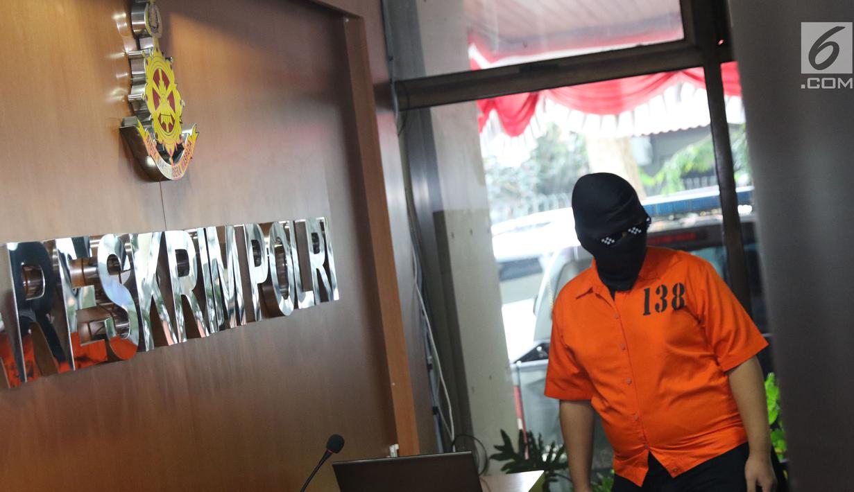 Salah satu tersangka dari kelompok hacker yang meretas situs PN Sulawesi Tenggara diperlihatkan saat rilis di Bareskrim Mabes Polri, Jakarta, Jumat (9/11). Empat pelaku ditangkap, mereka tergabung kelompok Black Hat.  (Liputan6.com/Helmi Fithriansyah)