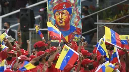 Pendukung membawa gambar mendiang mantan Presiden Hugo Chavez selama parade militer menandai Hari Kemerdekaan di Caracas, Venezuela, Senin (5/7/2021). Venezuela menandai 210 tahun deklarasi kemerdekaan mereka dari Spanyol. (AP Photo/Matias Delacroix)