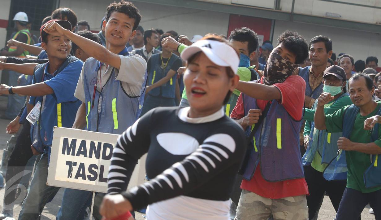 Pekerja renovasi Stadion Utama GBK mengikuti instruktur senam sebelum beraktivitas di kawasan Senayan, Jakarta, Jumat (17/3). Senam dilakukan untuk menjaga kebugaran pekerja yang rutin diadakan setiap Jumat pagi. (Liputan6.com/Immanuel Antonius)