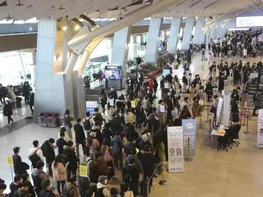 Penumpang yang mengenakan masker antre untuk menaiki pesawat pada malam liburan Tahun Baru Imlek di terminal penerbangan domestik bandara Gimpo di Seoul, Korea Selatan, Kamis (11/2/2021). Liburan Tahun Baru Imlek adalah salah satu hari libur tradisional utama negara itu. (AP Photo/Ahn Young-joon)