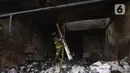 Petugas pemadam kebakaran melakukan pembasahan bioskop Grand Theater yang terbakar di Simpang Lima Senen, Jakarta, Jumat (9/10/2020). Unjuk rasa menentang disahkannya Omnibus Law UU Cipta Kerja berujung aksi anarkis merusak berbagai fasilitas umum pada Kamis malam (8/10). (merdeka.com/Dwi Narwoko)