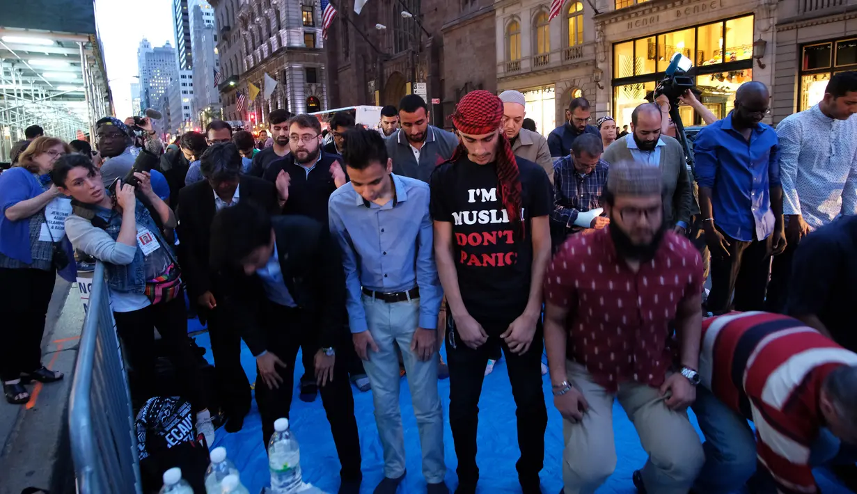 Umat muslim melaksanakan salat berjemaah usai berbuka puasa bersama di dekat Trump Tower, New York, Kamis (1/6). Ratusan muslim demo memprotes retorika dan kebijakan Donald Trump yang xenophobia, seperti larangan perayaan Ramadan di AS. (Jewel SAMAD/AFP)