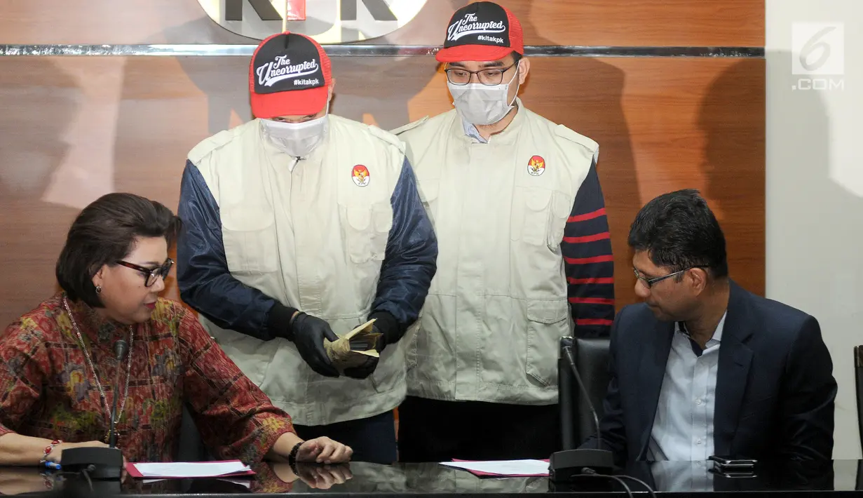 Petugas bersama Wakil Ketua KPK Basaria Panjaitan dan Laode M Syarif bersiap menunjukkan barang bukti hasil OTT Bupati Muara Enim di Gedung KPK, Jakarta, Selasa (3/9/2019). KPK mengamankan 350.000 dollar AS terkait suap 16 proyek peningkatan pembangunan jalan di Muara Enim. (merdeka.com/Dwi Narwoko)