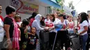 Relawan dari Gerakan Aksi Srikandi Coblos Ahok (Gadis Ahok) memberikan sapu dan tempat sampah ke warga di kawasan Cipete, Jakarta Selatan, Senin (26/12). Sebanyak 150an kantong sampah dan sapu dibagikan ke warga. (Liputan6.com/Gempur M Surya)