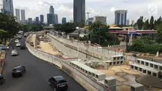Kendaraan melintas di samping pembangunan proyek underpass Mampang-Kuningan, Jakarta, Senin (29/1). Underpass dengan panjang 860 meter ini kemungkinan besar baru bisa rampung pada April 2018 mendatang. (Liputan6.com/Immanuel Antonius)