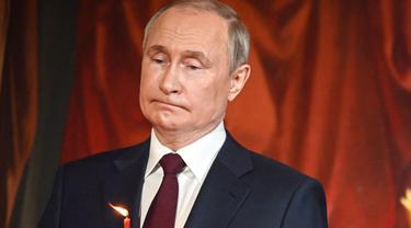 Vladimir Putin terlihat menggigit bibirnya pada misa tengah malam di Moskow. foto: AFP