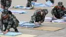 Mahasiswa baru belajar melipat selimut selama sesi pelatihan militer di sebuah kampus di Yangzhou, Jiangsu, China, Jumat (6/9/2019). Pelatihan militer bagi mahasiswa baru di China  biasanya dilakukan pada akhir liburan musim panas. (STR/AFP)