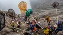 Sejumlah orang mencoba menangkap sajen yang dilemparkan ke kawah dalam ritual Yadnya Kasada di Gunung Bromo, Probolinggo, Jawa Timur, Kamis (18/7/2019). Ritual ini diselenggarakan berabad-abad silam saat manusia pertama kali mendiami kawasan kaki Gunung Bromo. (JUNI KRISWANTO/AFP)