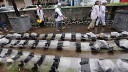 Peserta aksi damai 2 Desember berjalan di samping helm dan tameng polisi yang diletakan di trotoar kawasan Sarinah, Jakarta, Jumat (2/12). Meski aksi 2 Desember telah usai, mereka tetap berjaga sampai situasi kondusif. (Liputan6.com/Ferbian Pradolo)