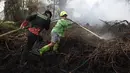Petugas pemadam kebakaran menyemprotkan air untuk memadamkan api yang melalap lahan gambut di Kubu Raya, Kalimantan Barat, Indonesia, Selasa, 11 Agustus 2026. (Foto AP/Stefanus Taman)