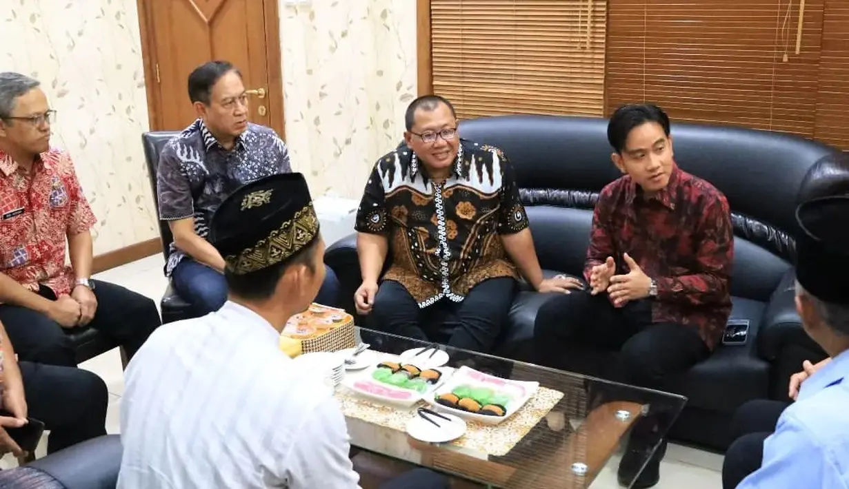 Gibran tampil rapi mengenakan kemeja bercorak batik merah lengan panjang dan celana panjang hitam yang serasi. [Foto: Instagram/dprdkotasurakarta]