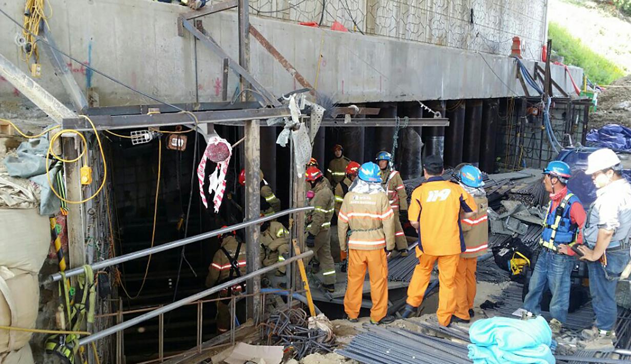 Tim penyelamat dikerahkan mengevakuasi korban robohnya konstruksi kereta bawah tanah di kota Namyangju, dekat Seoul, Korsel, Rabu (1/6). Belum bisa dipastikan penyebab insiden ini, namun saksi mata menyebut ada ledakan besar di lokasi proyek. (AFP)